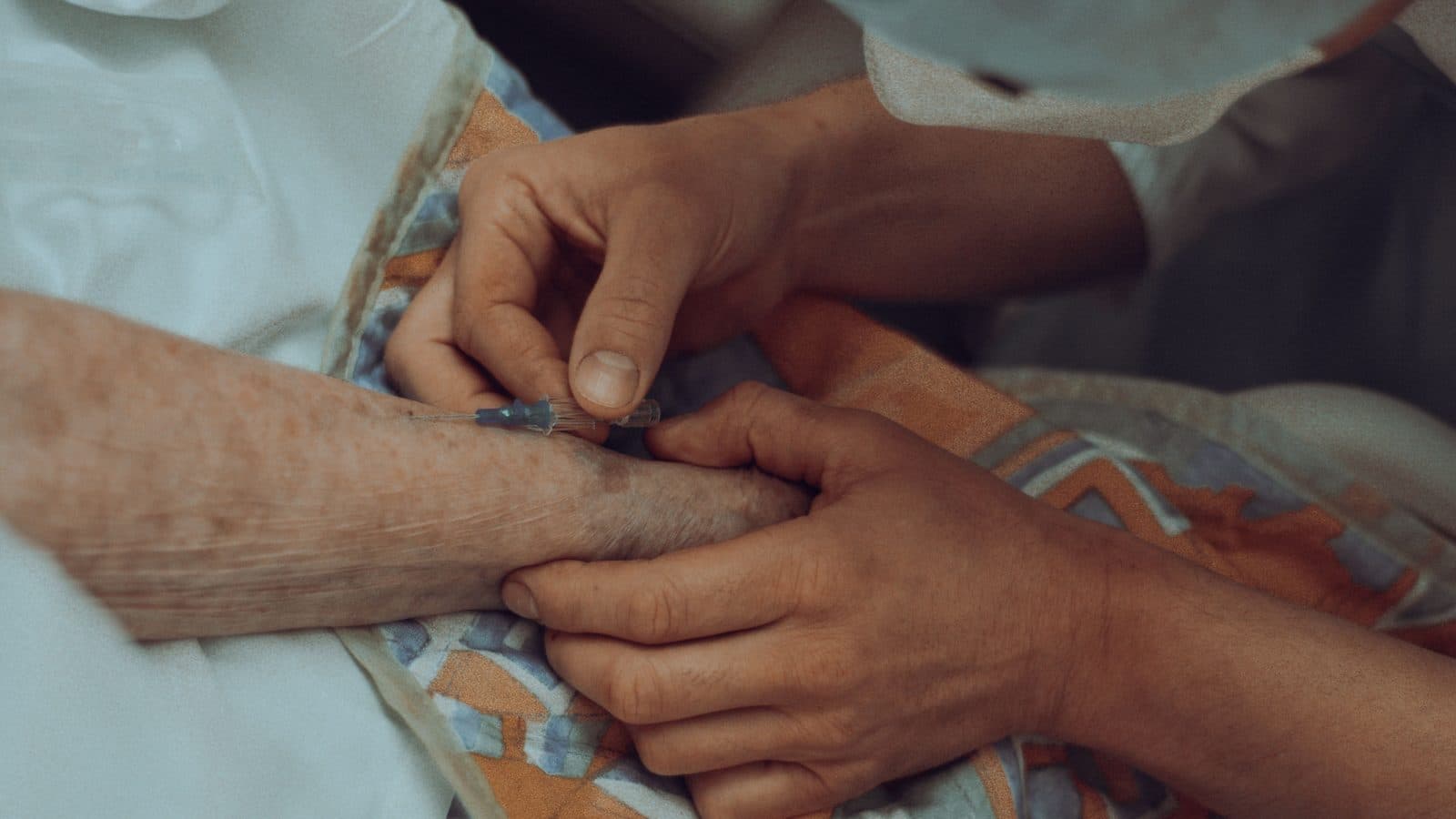 A carer's hands holding an older person's hands.